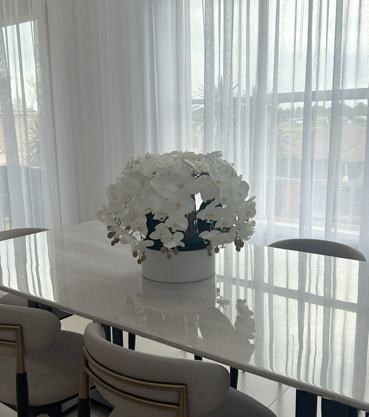 White orchid arrangement in white vase