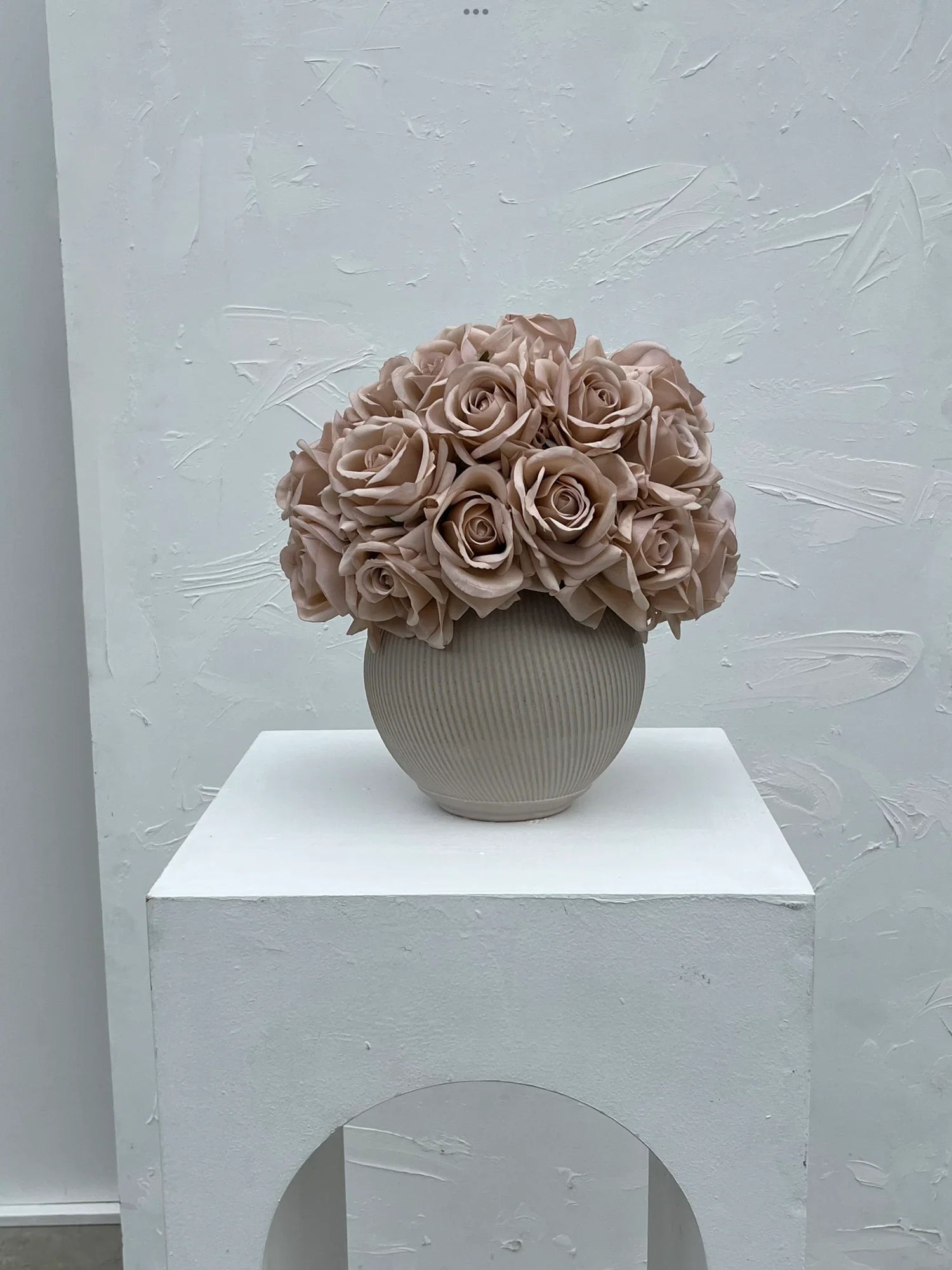 Artificial rose arrangements and faux rose stems styled in vase