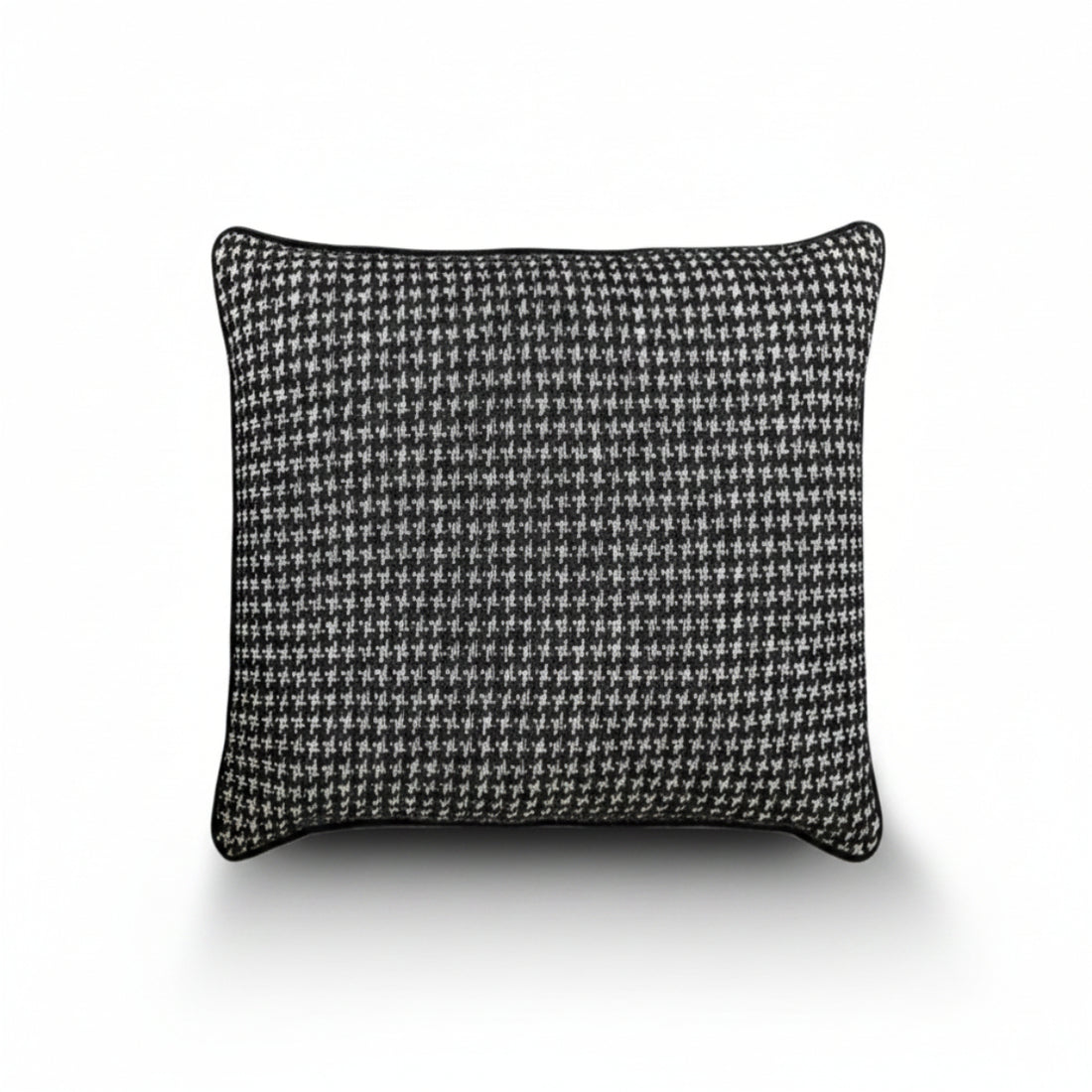 A square throw pillow featuring a classic black and white houndstooth pattern, finished with a solid black piped edge, shown against a plain white background with a soft drop shadow.