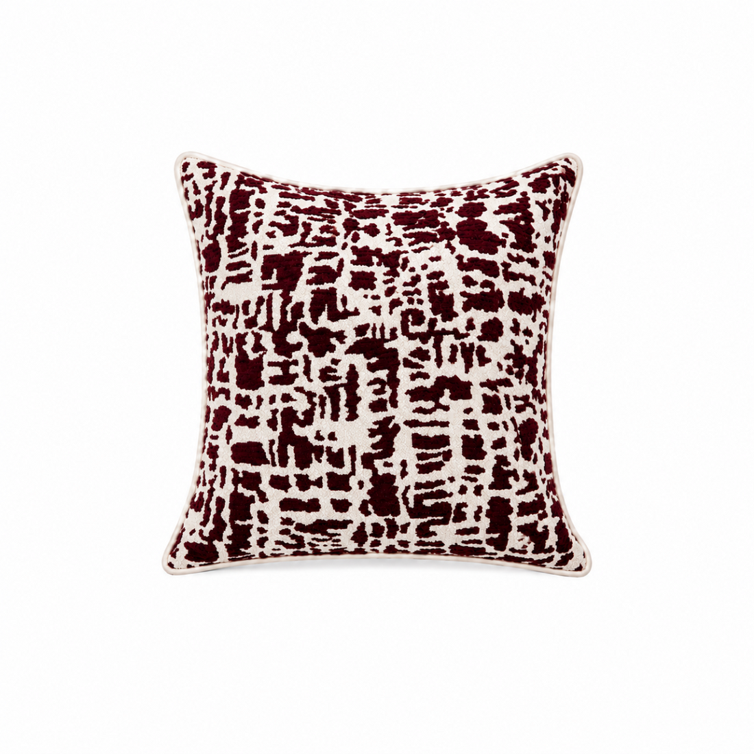 A square throw pillow featuring an abstract, distressed brushstroke pattern in deep burgundy and cream, with a thin cream piped edge, shown against a plain white background.